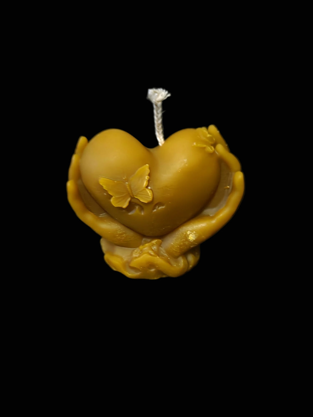 Figura de corazón entre manos de cera natural de abejas